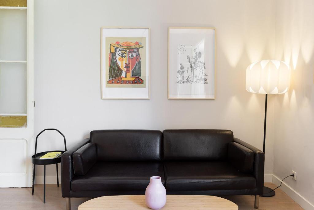 a living room with a black couch and a table at Sagrada Familia IV by Enjoy Apartments in Barcelona