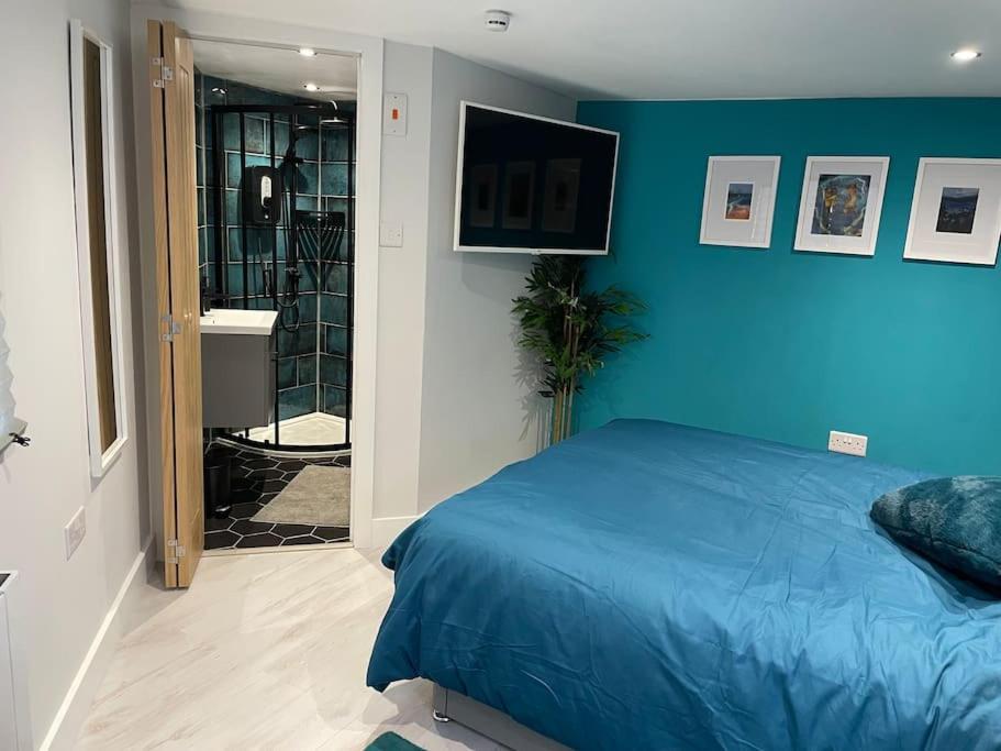 um quarto azul com uma cama e uma casa de banho em Cosy cabin with private bathroom 
