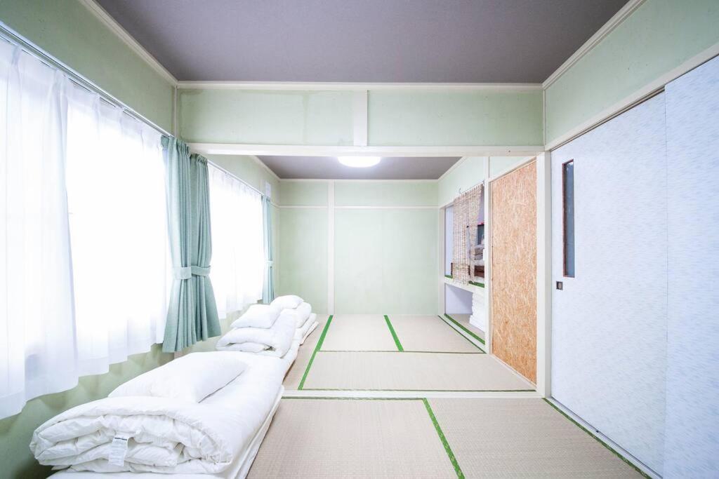 Postel nebo postele na pokoji v ubytování Otaru Shikkui Cottage