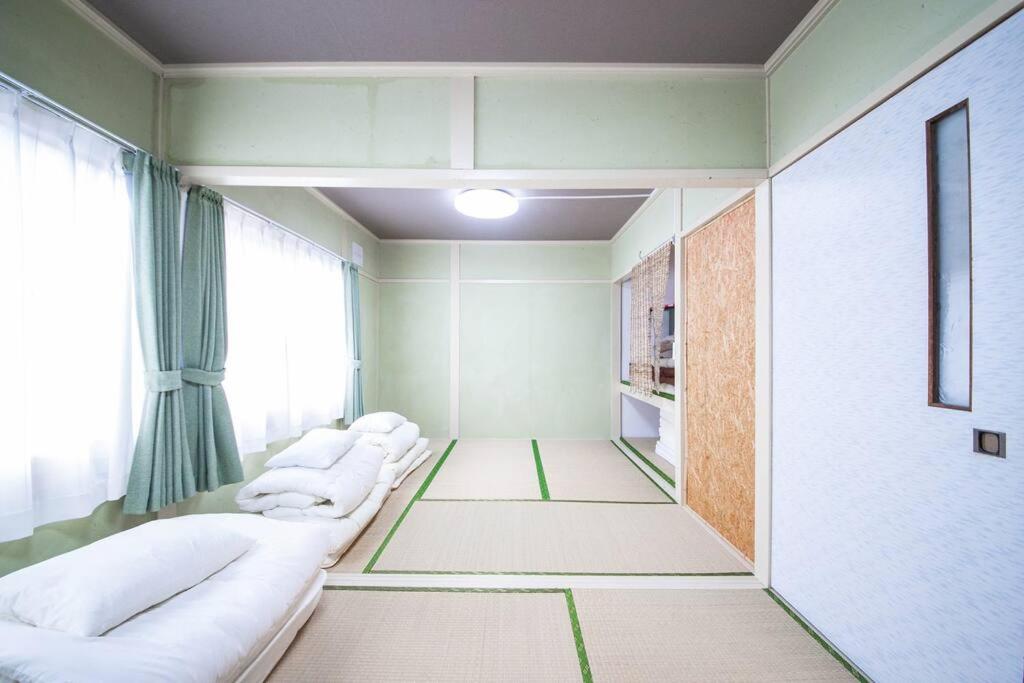 Postel nebo postele na pokoji v ubytování Otaru Shikkui Cottage