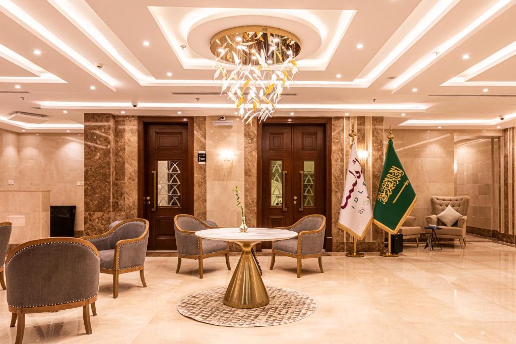 a lobby with a table and chairs and a chandelier at idles By Staytion Serviced Apartments in Jeddah