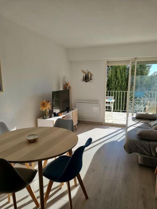 un salon avec une table, des chaises et un canapé dans l'établissement Appartement 2 pièces tout confort, à Saint-Raphaël