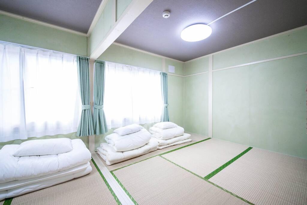 Postel nebo postele na pokoji v ubytování Otaru Shikkui Cottage