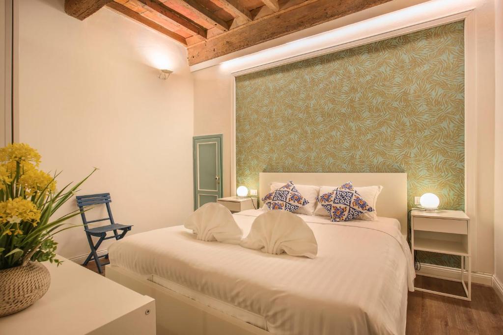 a bedroom with a white bed with a green wall at La Sinagoga Suite-Hosted by Sweetstay in Florence