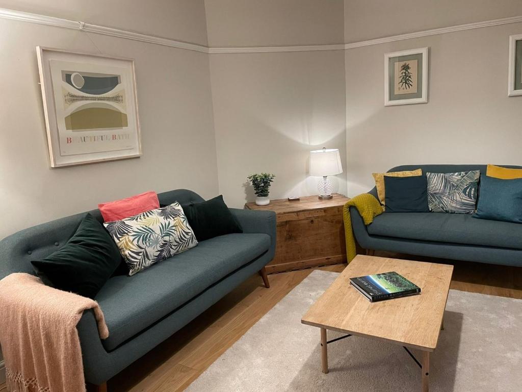 a living room with two couches and a coffee table at No 12 - Stylish & homely 3 bed with parking close to city centre in Bath