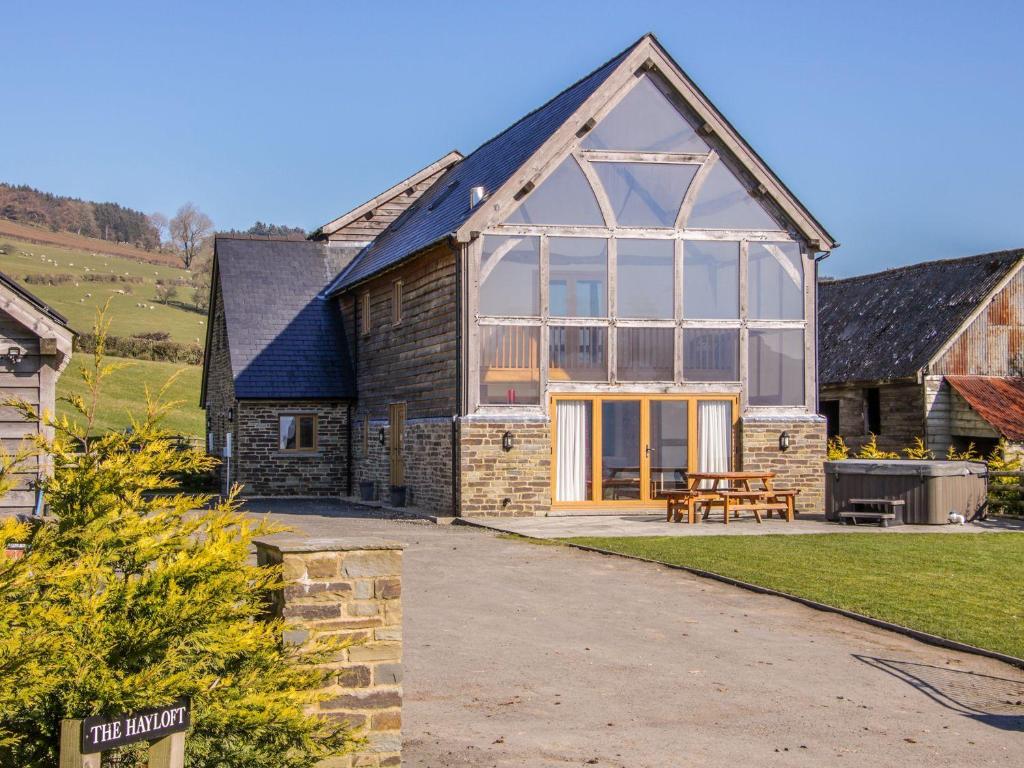 a barn conversion with a large conservatory on a house at The Hayloft in Knighton