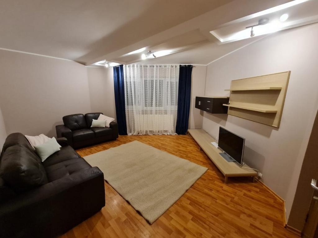a living room with a couch and a television at Apartament Avram in Petroşani