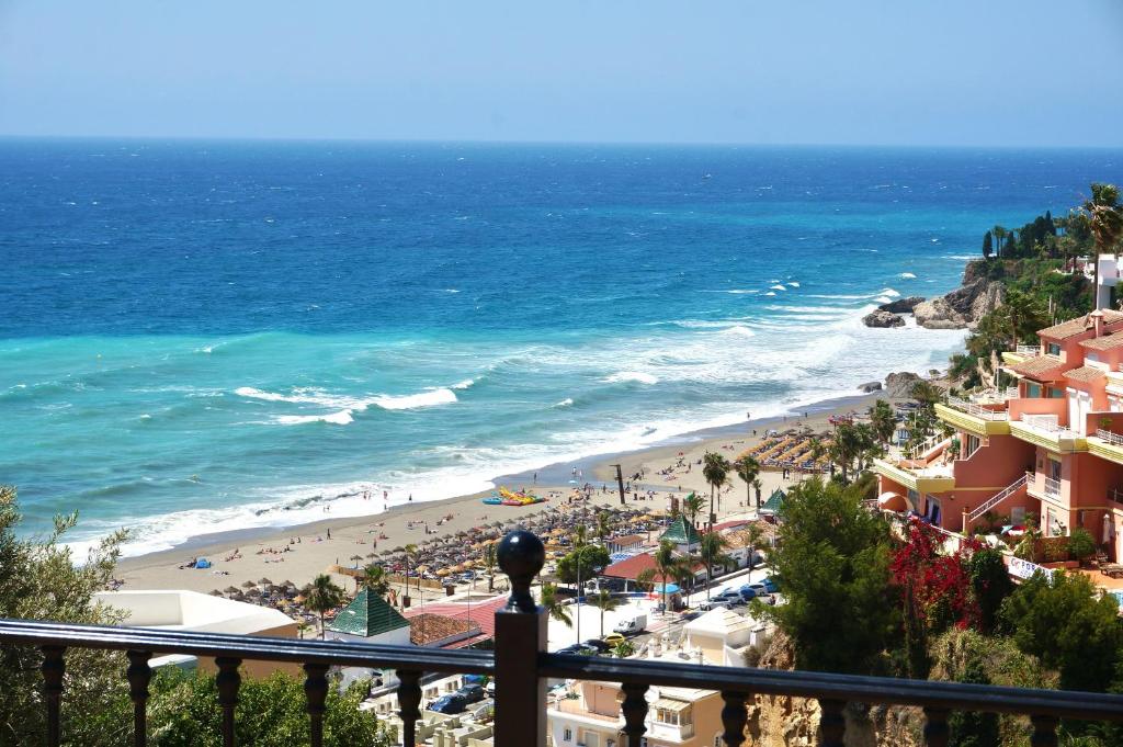 a view of a beach and the ocean from a balcony at Casa Alba in Nerja