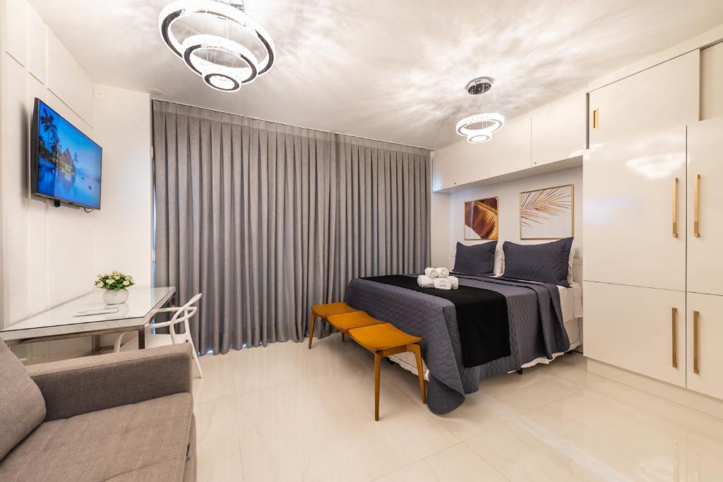 Rosemari's Apartments 2 Studios Luxuosos في ساو باولو: غرفة نوم بسرير وطاولة واريكة