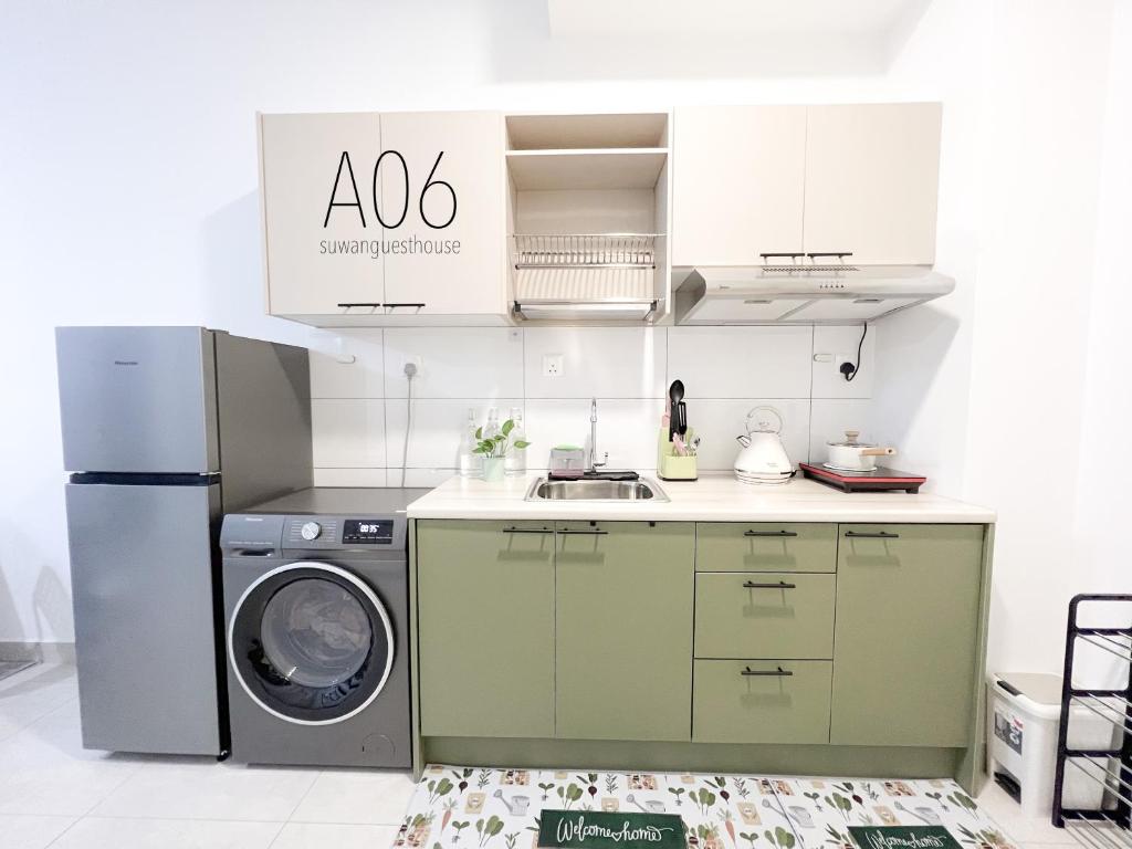 uma cozinha com uma máquina de lavar roupa e um lavatório em SUWAN Guesthouse A06 - 2BR Apartment with Pool Near UKM em Kajang