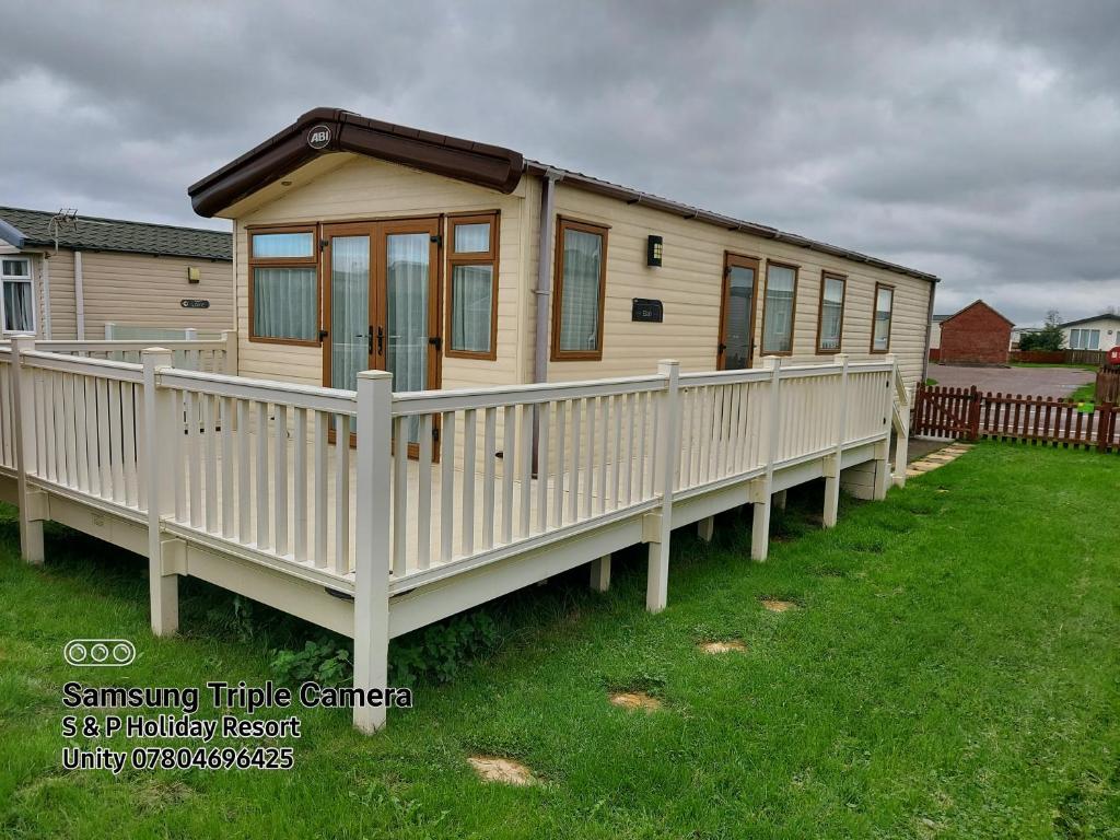 a tiny house on a deck in a yard at 149 Holiday Resort Unity 3 bedroom passes included in Brean
