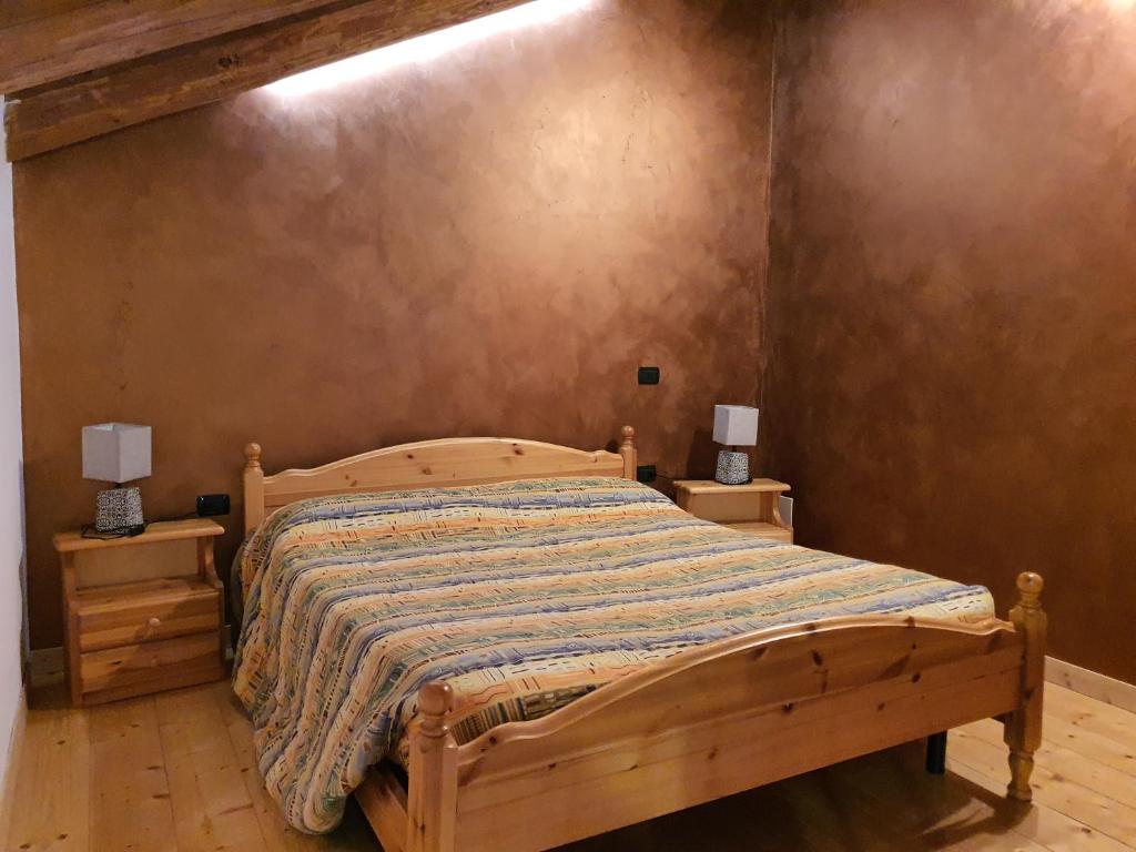 a bedroom with a wooden bed with two night stands at Agriturismo al pra di muriet in Susa