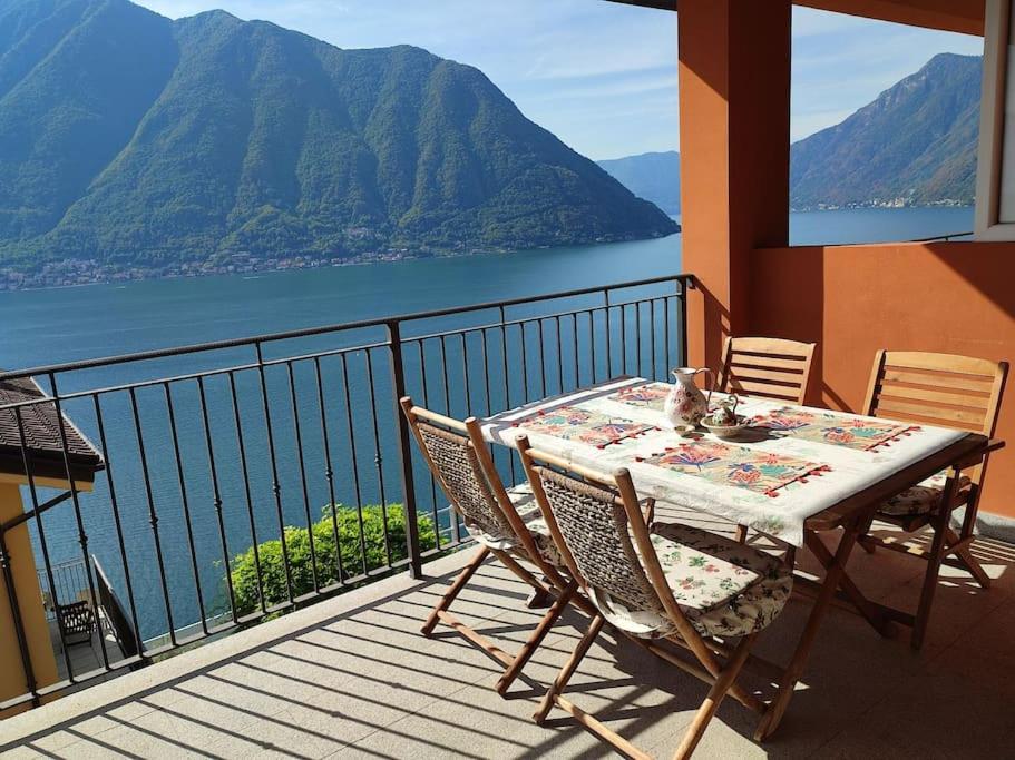 d'une table et de chaises sur un balcon avec vue sur l'eau. dans l'établissement Vista lago panoramica, à Colonno