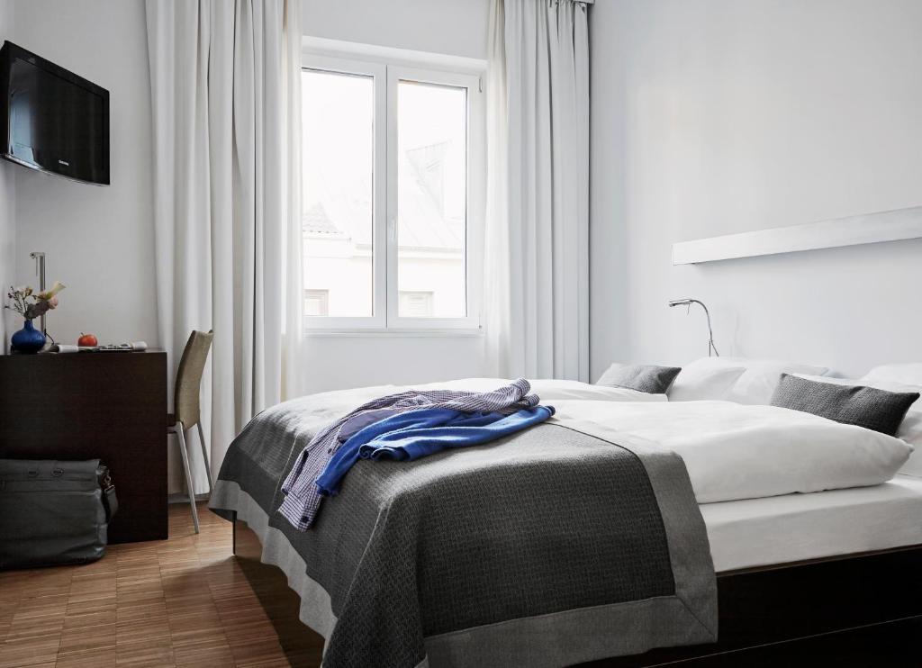 a white bedroom with a bed and a window at Wedina Budget in Hamburg