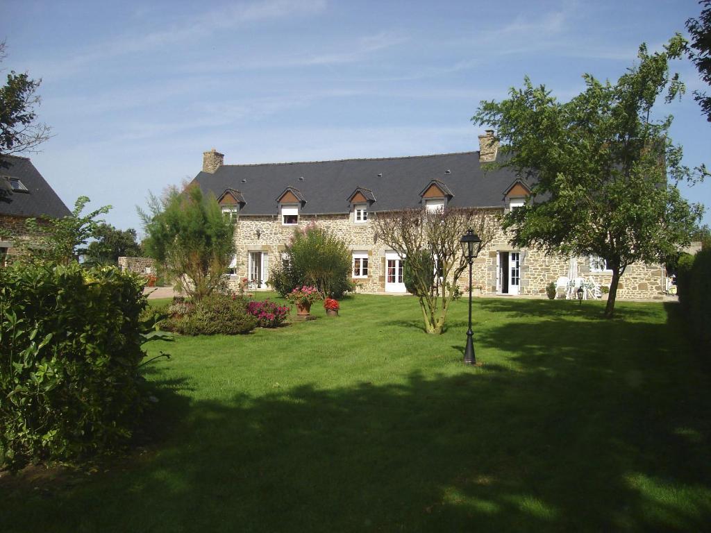 a large stone house with a large yard at Chambres d'Hotes Les Sageais in Baguer-Morvan