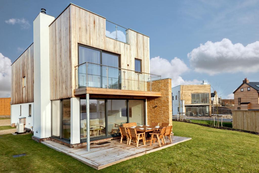 a wooden house with a table and chairs at Luxury property with access into Spa on a nature reserve Beaumont Village 14 in Warmwell