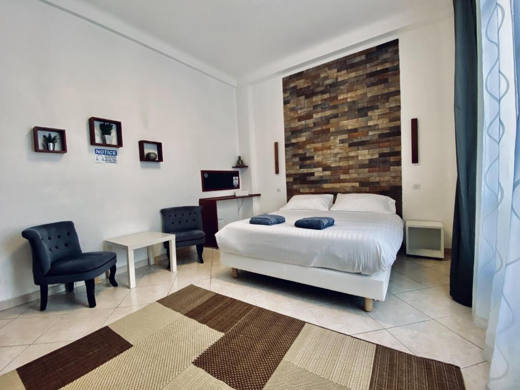 une chambre avec un lit blanc et un mur de briques dans l'établissement Appartement Auber, à Nice