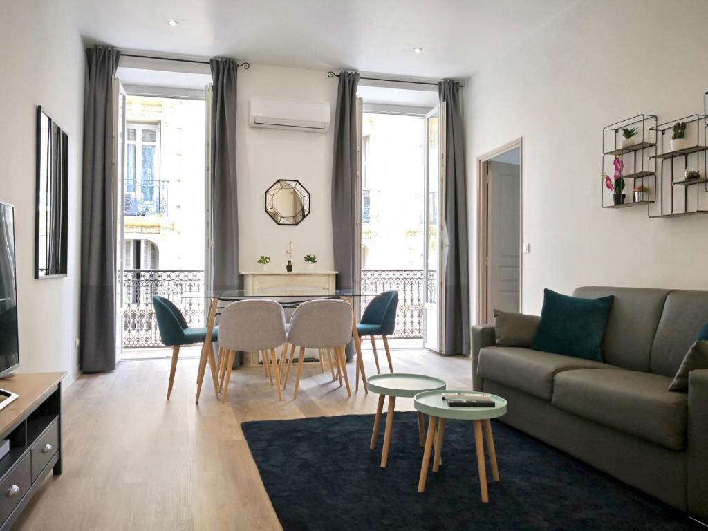 un salon avec un canapé, une table et des chaises dans l'établissement Appartement Urban 3, à Nice
