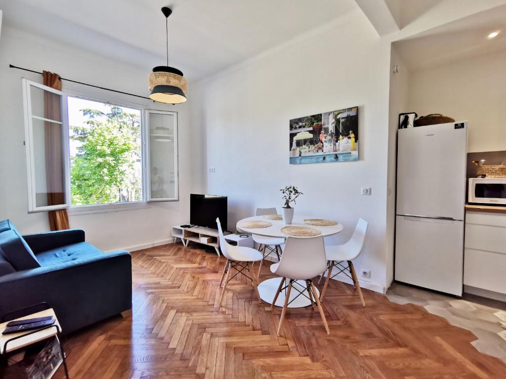 a living room with a table and a refrigerator at LE FOCH by Booking Guys in Villefranche-sur-Mer