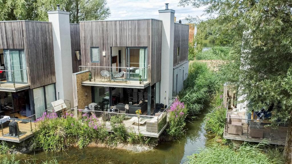 uma imagem de uma casa num rio em Lakeside roof terrace with Spa access Le Mirage em Somerford Keynes