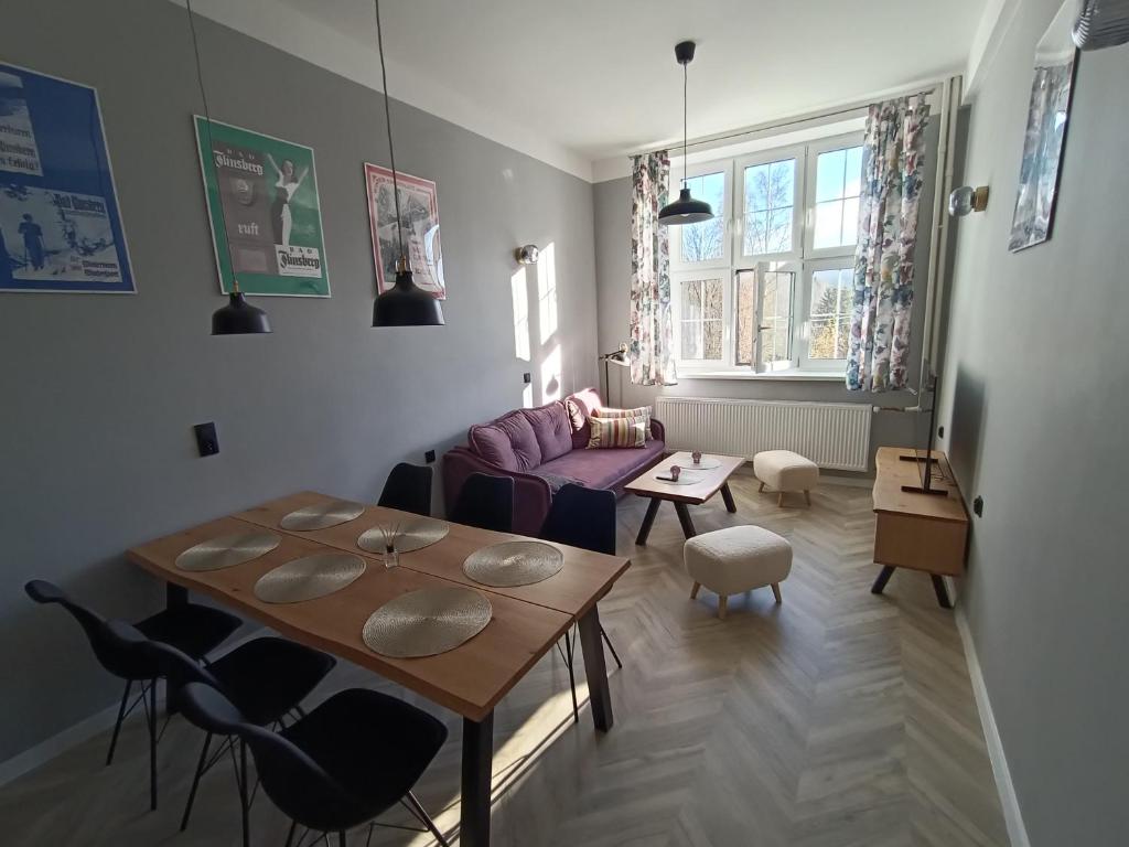 ein Wohnzimmer mit einem Tisch und einem Sofa in der Unterkunft Apartament Flins z garażem in Świeradów-Zdrój