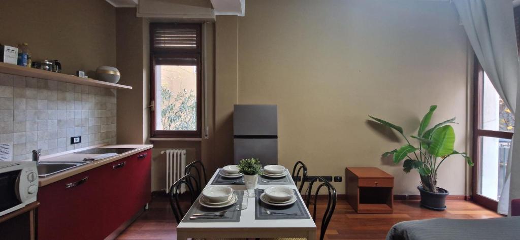 eine Küche mit einem Tisch und Geschirr darauf in der Unterkunft MilanRentals - Vigliani Apartments in Mailand