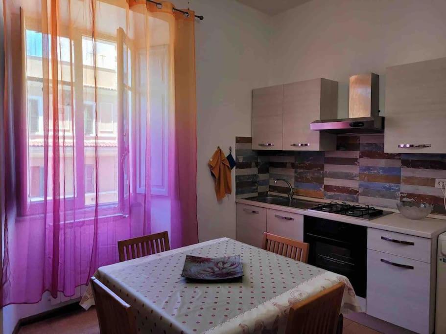 a kitchen with a table and a kitchen with pink lighting at ROME SWEET ROME - close to line A San Giovanni in Rome