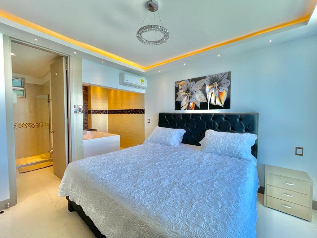 een slaapkamer met een groot bed en een badkamer bij Bocagrande beach apartamento in Cartagena