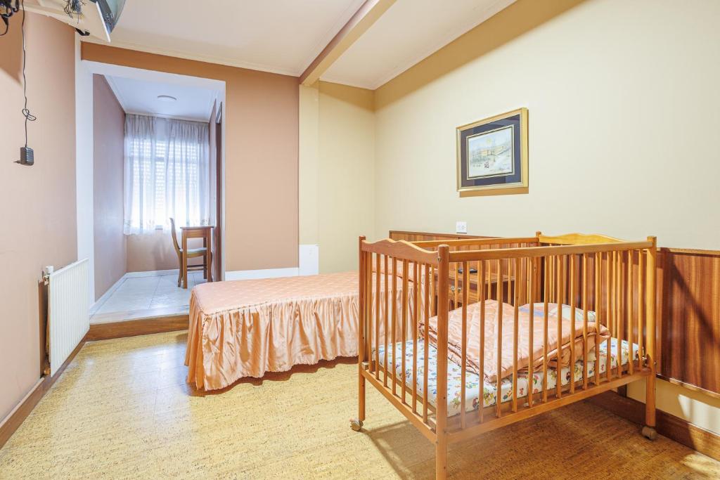 1 dormitorio con cuna en una habitación en Pensión Casa Pachín, en Taragoña