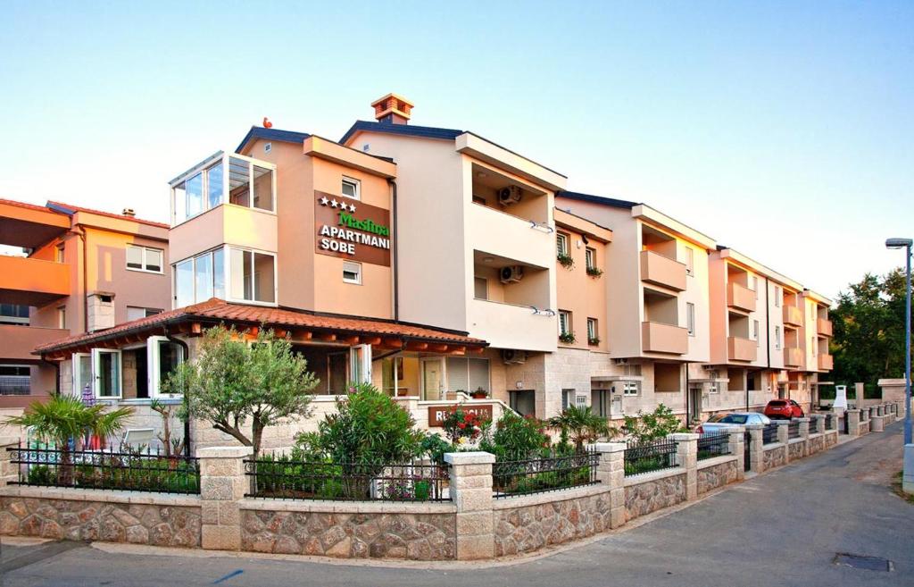 a row of apartment buildings on a street at Apartments Maslina III in Njivice