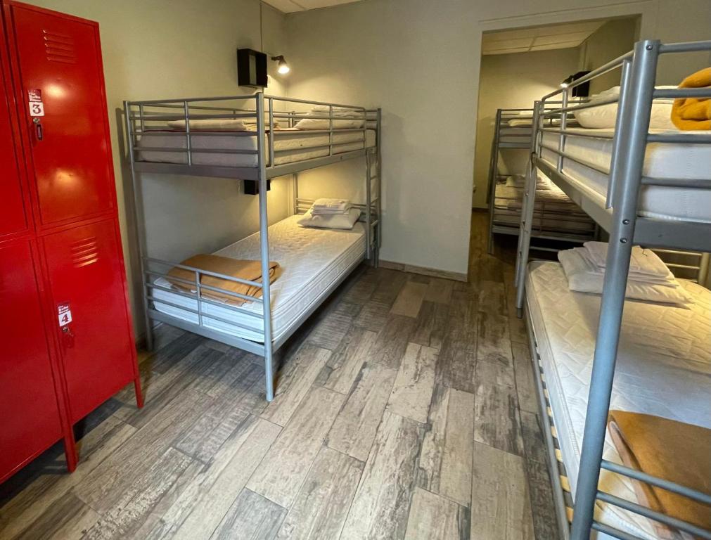 Pokój z 3 łóżkami piętrowymi i drewnianą podłogą w obiekcie Buba House w Barcelonie