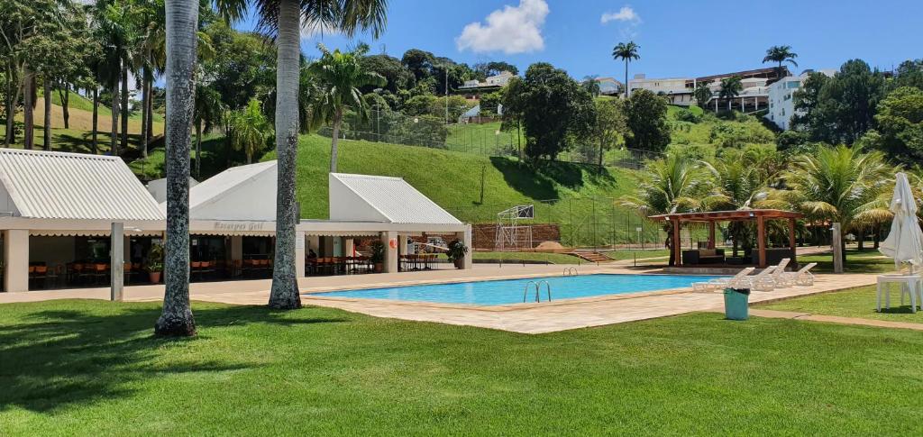 a resort with a swimming pool and palm trees at Hotel Escarpas do Lago By San Diego in Capitólio