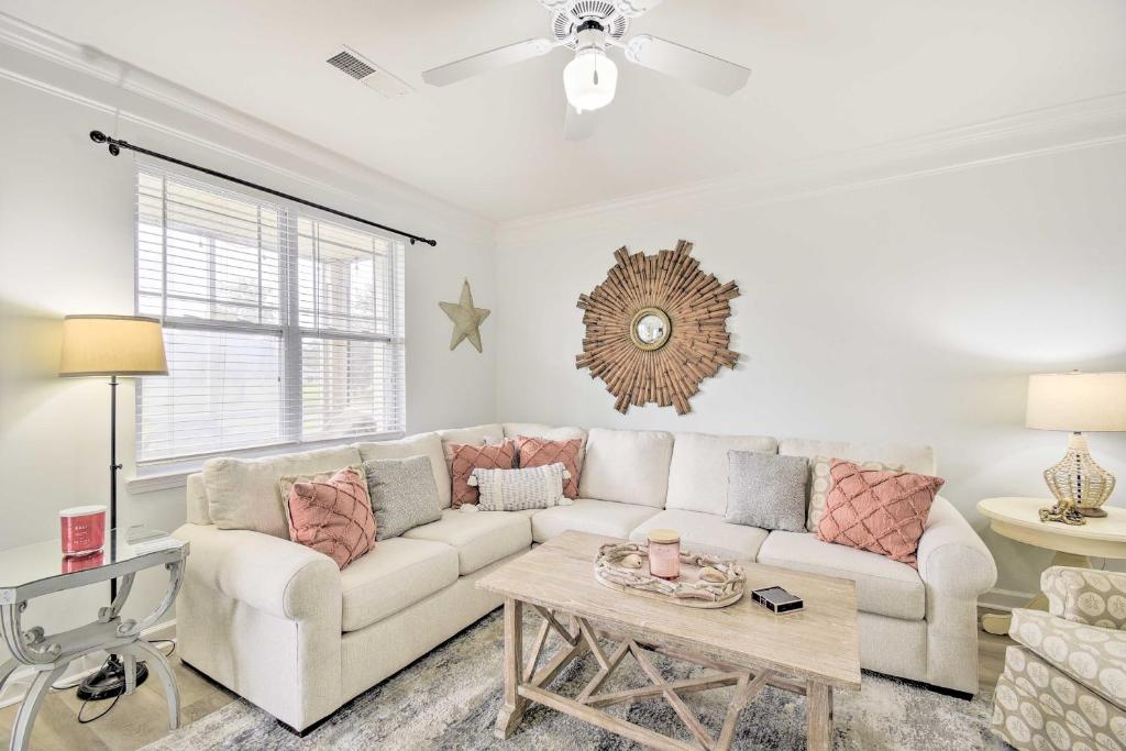 a living room with a white couch and a table at Calabash Condo with Patio and Golf Course Views! in Calabash