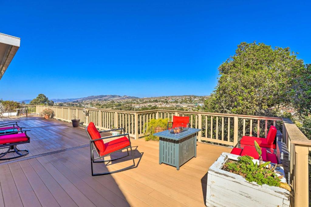 una terraza con sillas rojas y una mesa. en Retro House with Deck and Arroyo Grande View en Arroyo Grande