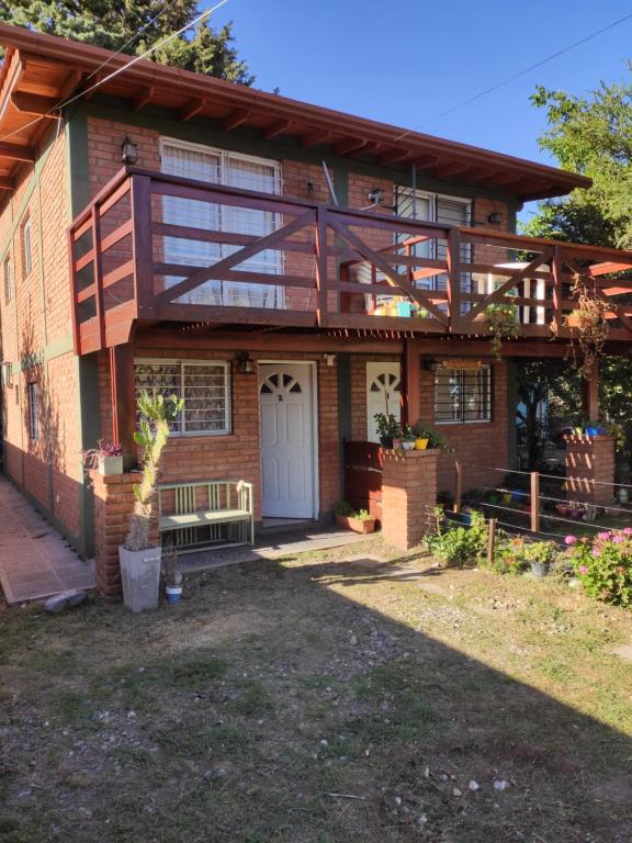 una casa con un balcón en el lateral. en Cabañas Céntricas Don Simon en Merlo