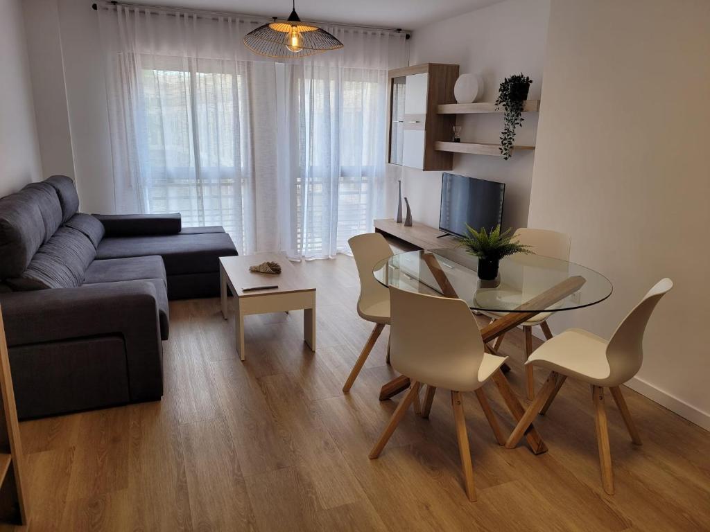 a living room with a glass table and a couch at Apartamento Ejido Centro in El Ejido