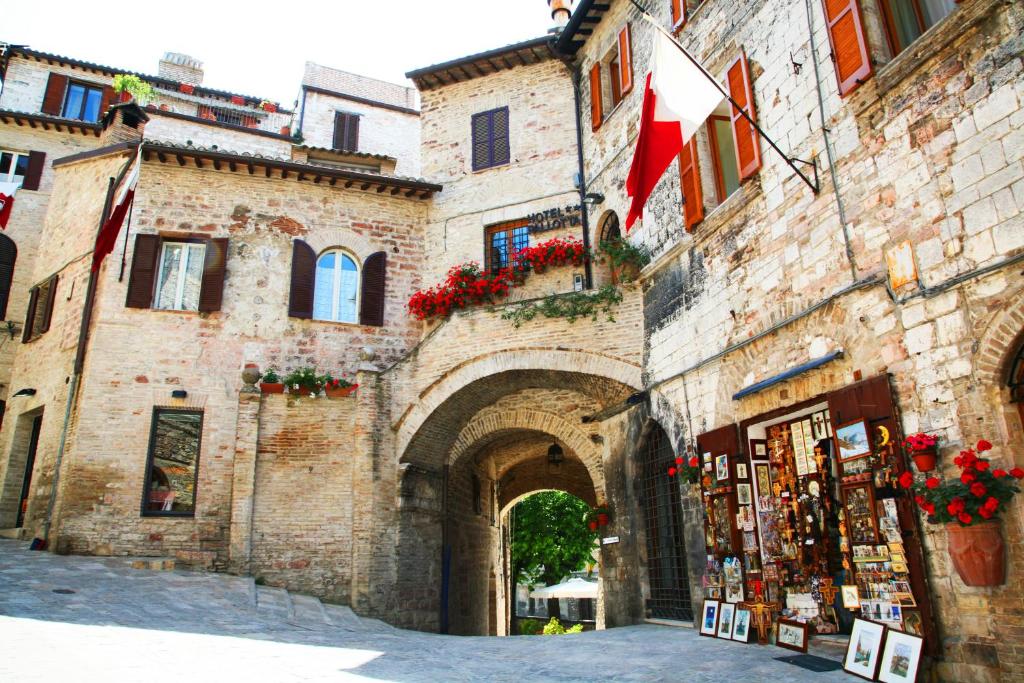 an old building with an archway in a city at Hotel Trattoria Pallotta in Assisi