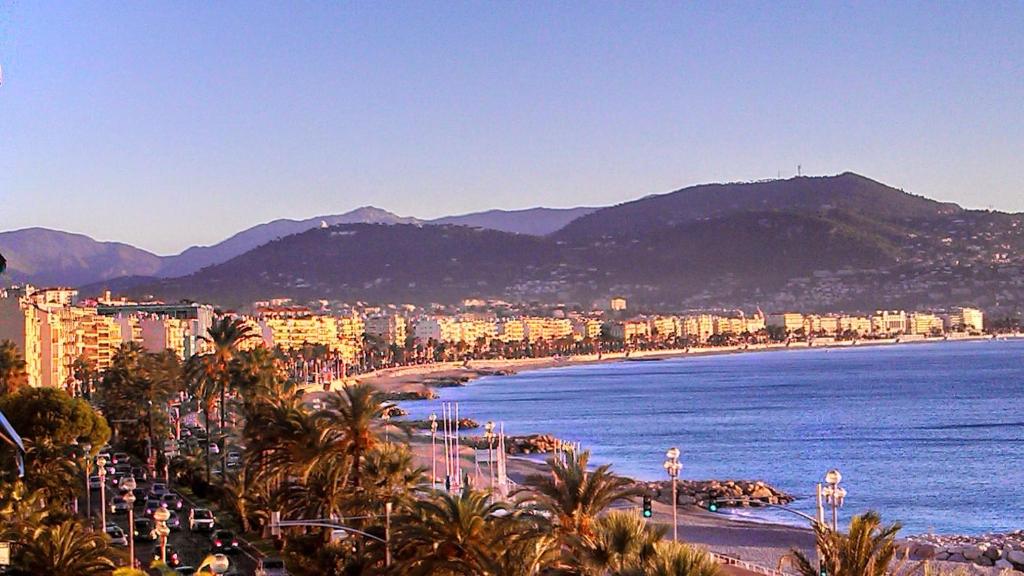 a view of a beach with a city and mountains at Apartment Le Margareth in Nice