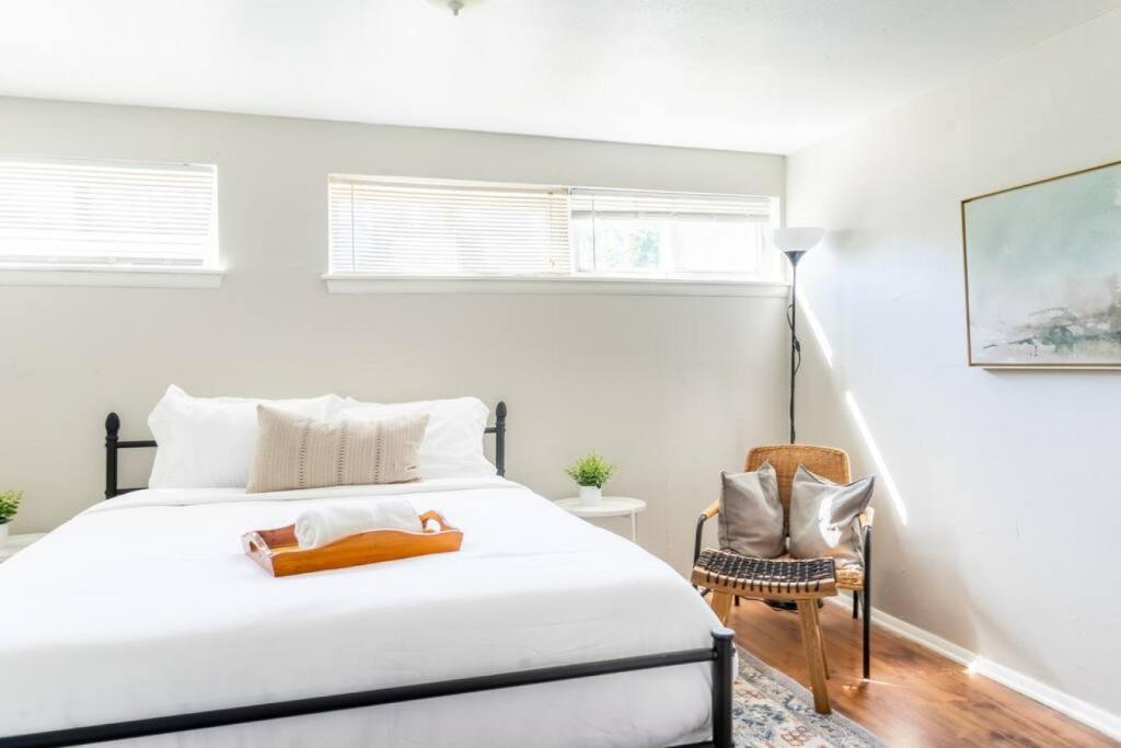 a white bedroom with a bed and a chair at Historic 1920s Brick Beauty in Medical District in Oklahoma City