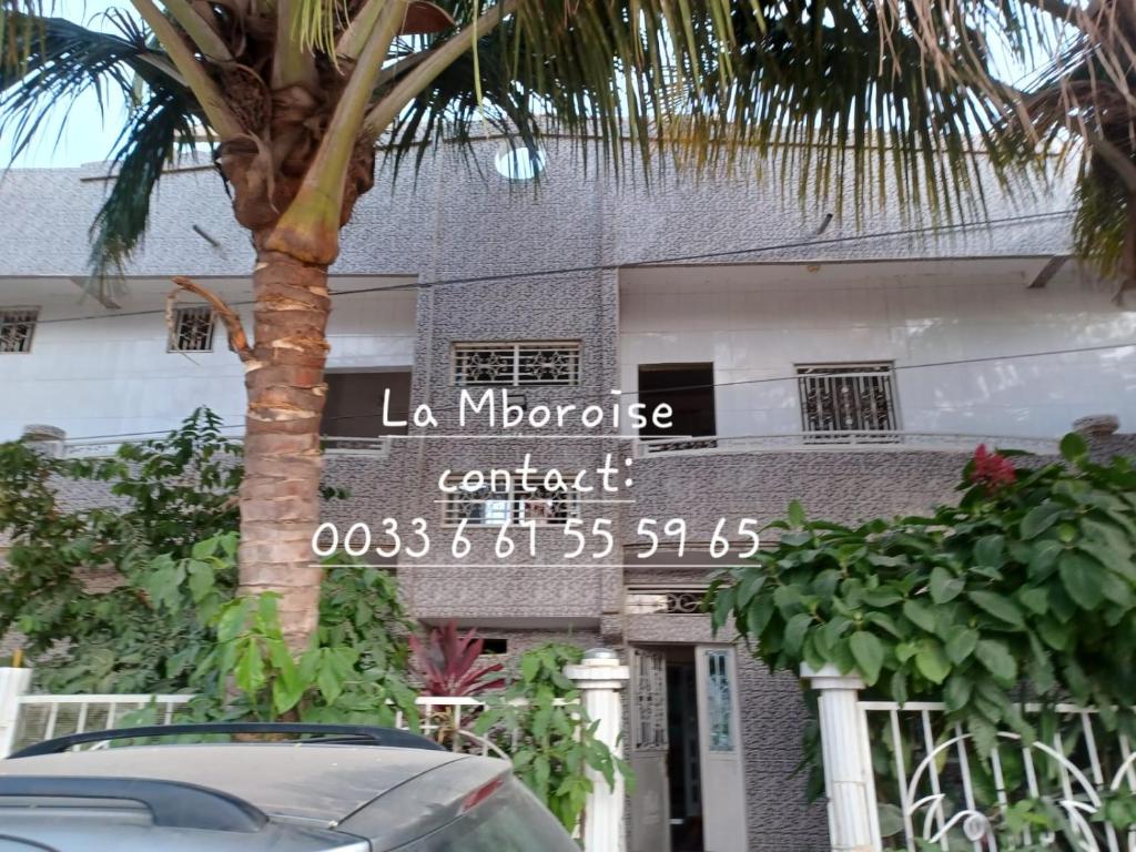 Mboro的住宿－La Mboroise，带有读取门禁联系标志的建筑