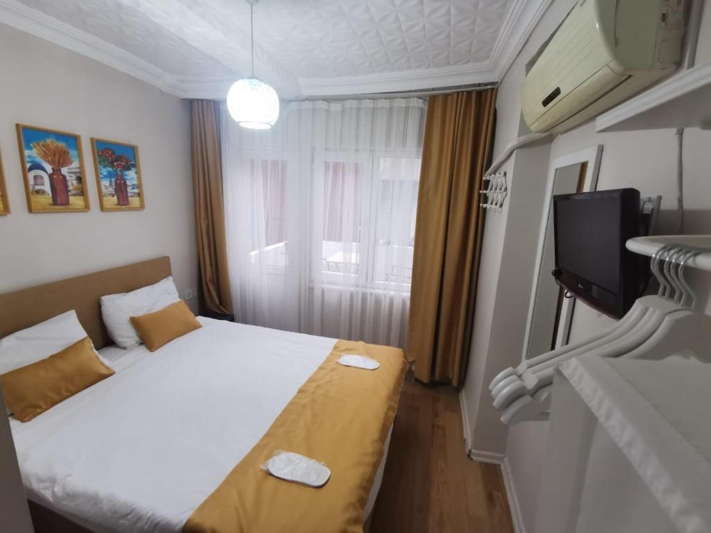 a hotel room with a bed and a television at Konut Wooden House in Istanbul
