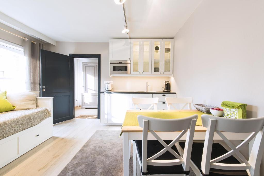 een keuken en een woonkamer met een gele tafel en stoelen bij Well Thirteen by Romy&Travis in Brugge