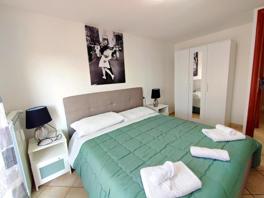 una camera da letto con un letto verde con due asciugamani di Attico Sea and Sunset a Lido di Ostia