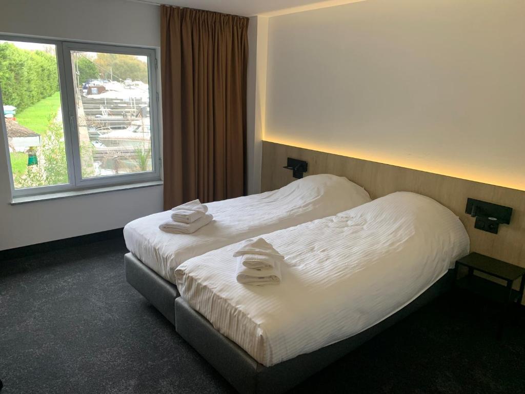 um quarto de hotel com uma cama com toalhas em OccO em Willebroek