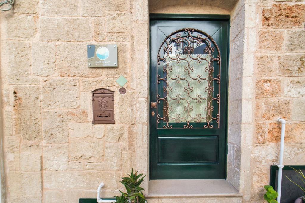 a green door on the side of a building at B&B Fiore di Mare in Polignano a Mare