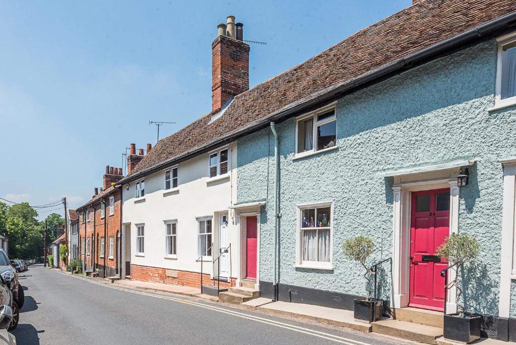 a row of houses with red doors on a street at Hall Cottage Woodbridge Air Manage Suffolk in Woodbridge