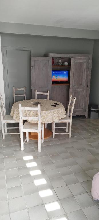 - une salle à manger avec une table, des chaises et une télévision dans l'établissement Studio Cosi idéalement placé Au Cœur de Ville, à Bourges