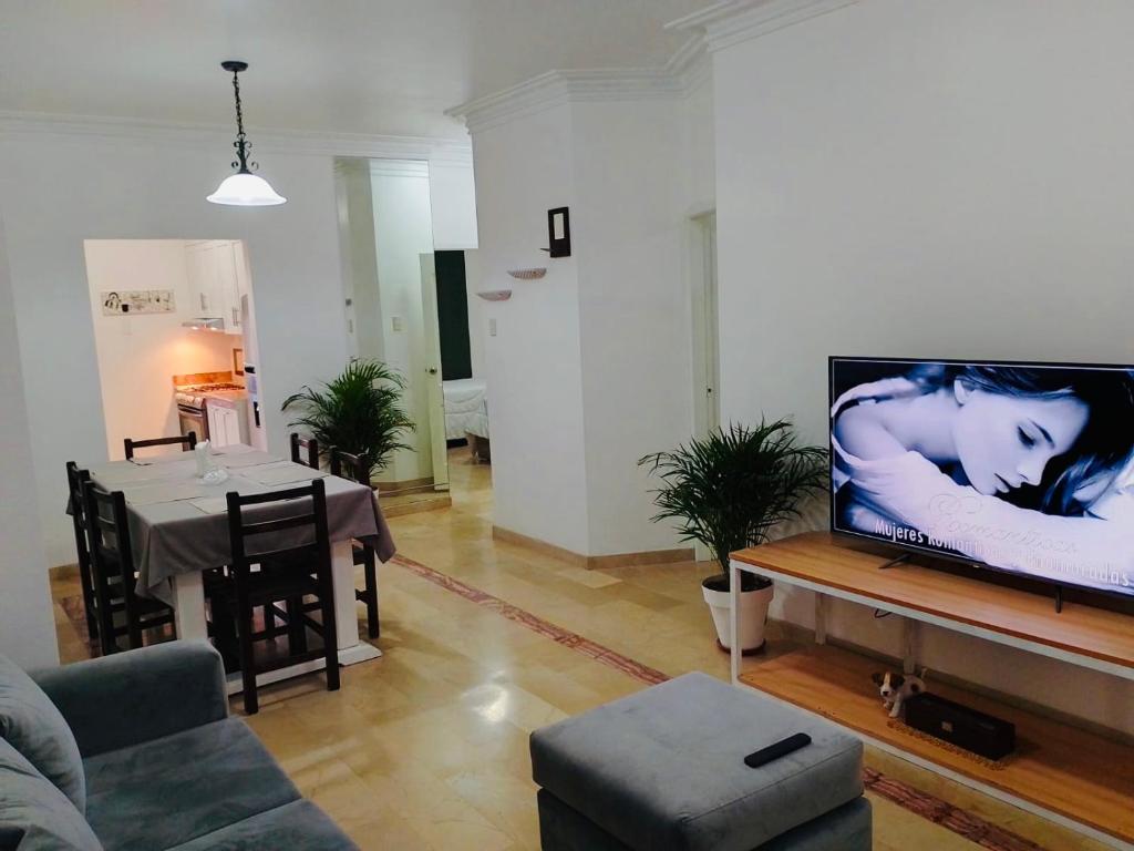 a living room with a couch and a tv and a table at Spacious 2-Bedroom Condo in Bellavista, Guayaquil in Guayaquil