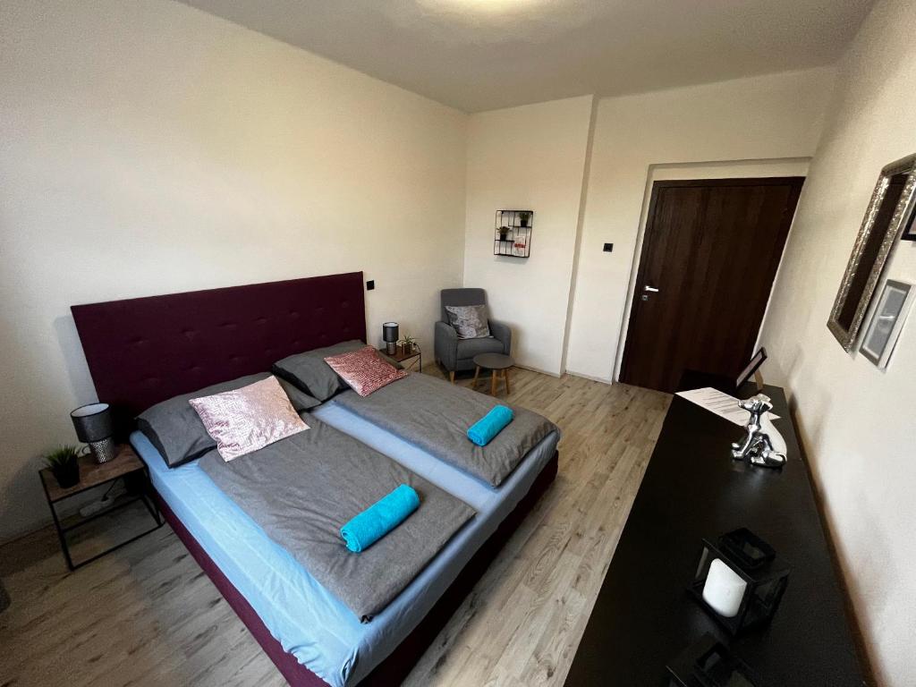 um quarto com uma cama grande e almofadas azuis em Large 3 bedroom apartment with city skyline view em Karlovy Vary