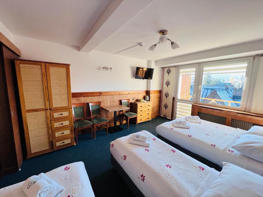 ザコパネにあるOśrodek Wypoczynkowy Startのベッド2台とデスクが備わるホテルルームです。